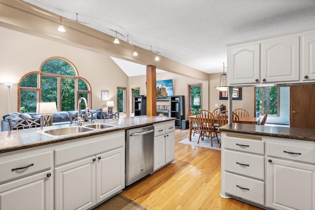 kitchen with light wood-type flooring, stainless steel dishwasher, white cabinets, track lighting, and sink