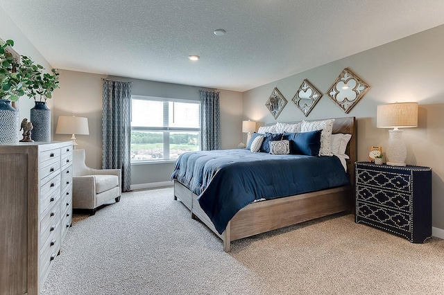 bedroom featuring light carpet and a textured ceiling