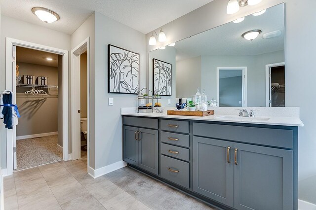 bathroom with toilet, a textured ceiling, and vanity