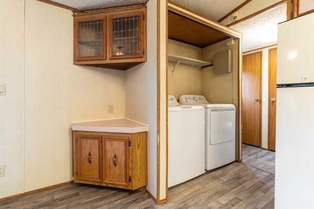 laundry area featuring hardwood / wood-style floors, separate washer and dryer, and a textured ceiling