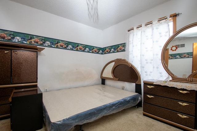 bedroom with a textured ceiling and light carpet