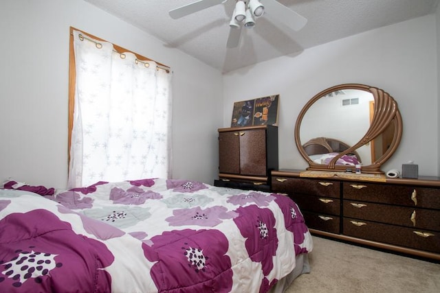 bedroom with a textured ceiling, ceiling fan, and carpet floors