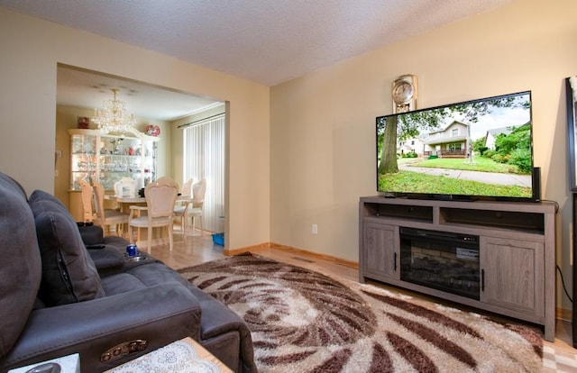 living room featuring a textured ceiling, an inviting chandelier, and light hardwood / wood-style floors