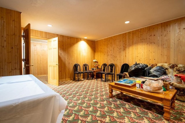 carpeted bedroom featuring ornamental molding and wooden walls