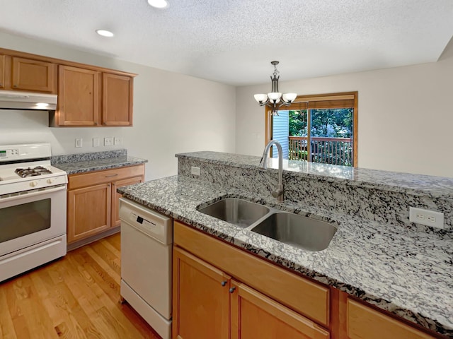 kitchen featuring sink, light hardwood / wood-style flooring, an inviting chandelier, white appliances, and light stone countertops