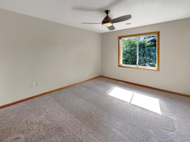 empty room with carpet floors, a textured ceiling, and ceiling fan