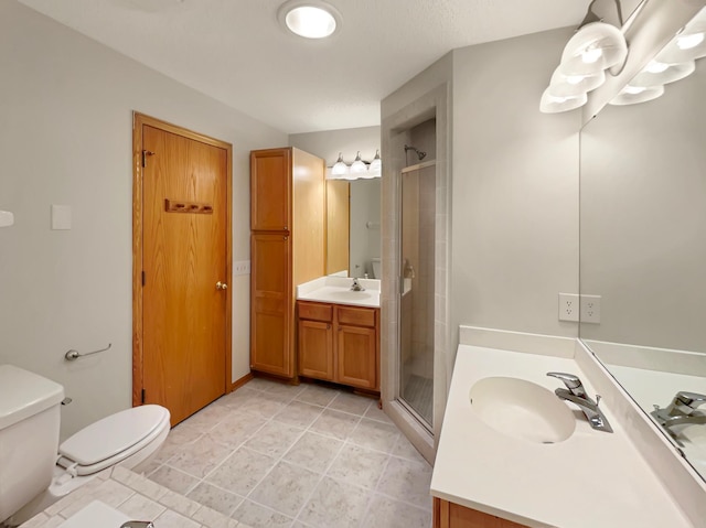 bathroom with tile patterned floors, walk in shower, vanity, and toilet