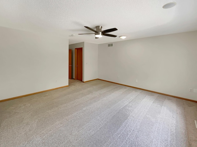 unfurnished room featuring ceiling fan, light colored carpet, and a textured ceiling