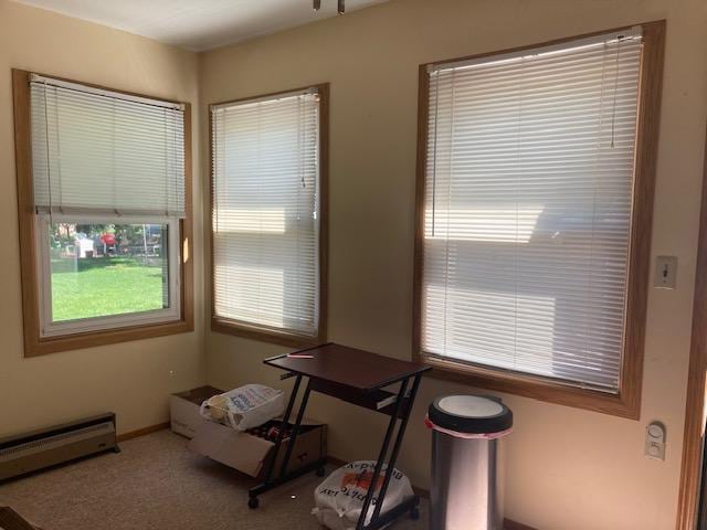 carpeted dining room featuring a baseboard heating unit and baseboards