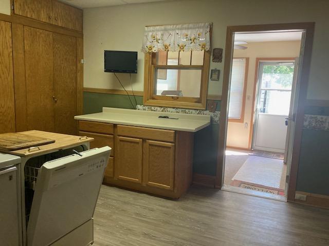 kitchen with brown cabinets, light countertops, and light wood finished floors