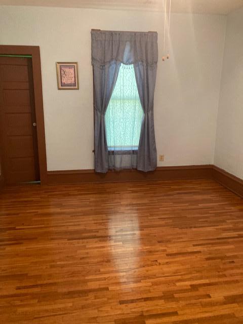 empty room with baseboards and wood finished floors