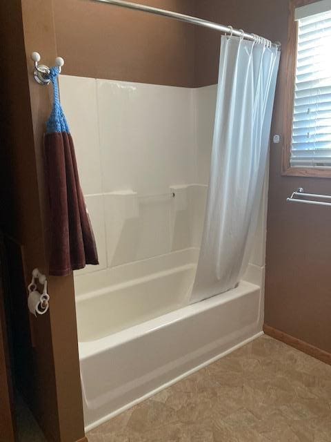 full bath with tile patterned floors, shower / tub combo with curtain, and baseboards