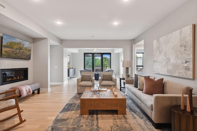 living room with light wood-type flooring and ceiling fan