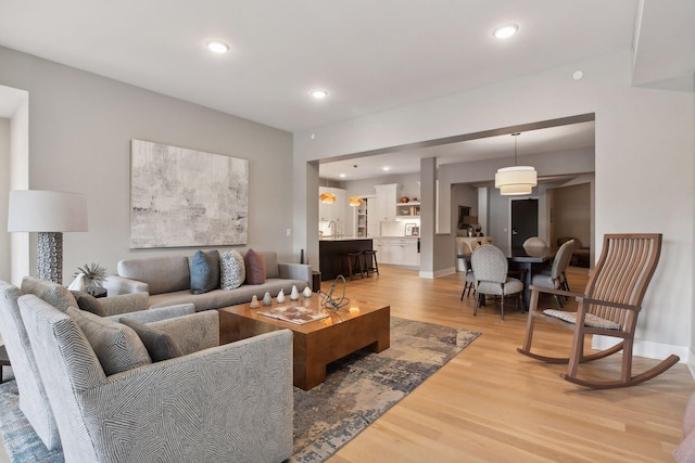 living area with light wood finished floors, recessed lighting, and baseboards