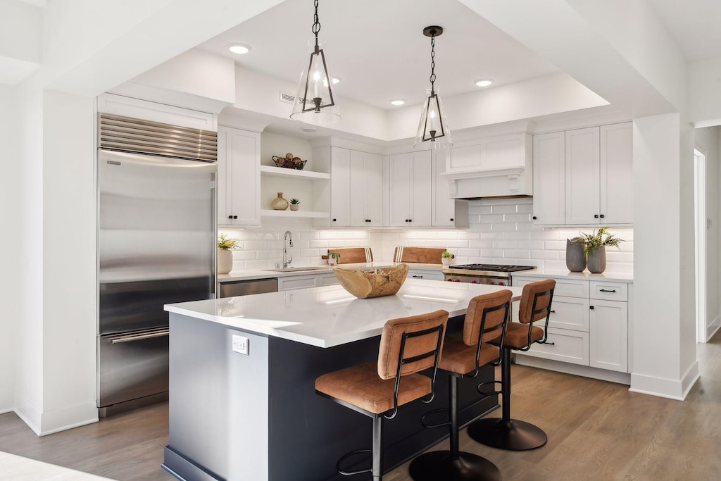 kitchen featuring a center island, white cabinets, stainless steel appliances, and sink