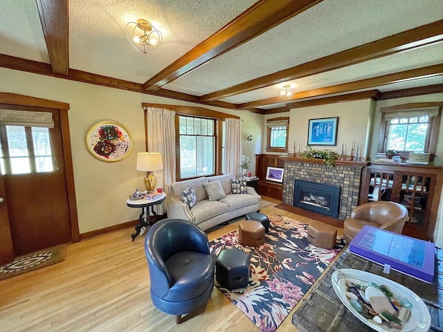 38364 200th St, Springfield, MN 56087 - living area featuring a textured ceiling, a fireplace, baseboards, beamed ceiling, and light wood-style flooring