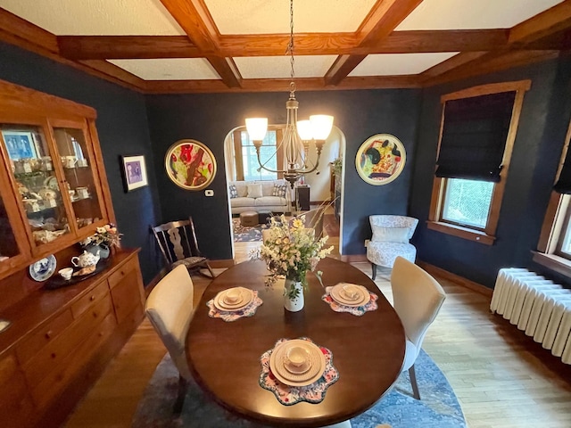 dining room with coffered ceiling, wood-type flooring, a chandelier, and radiator heating unit