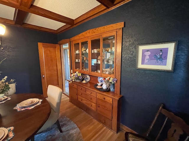 dining room with wood-type flooring, beam ceiling, and coffered ceiling