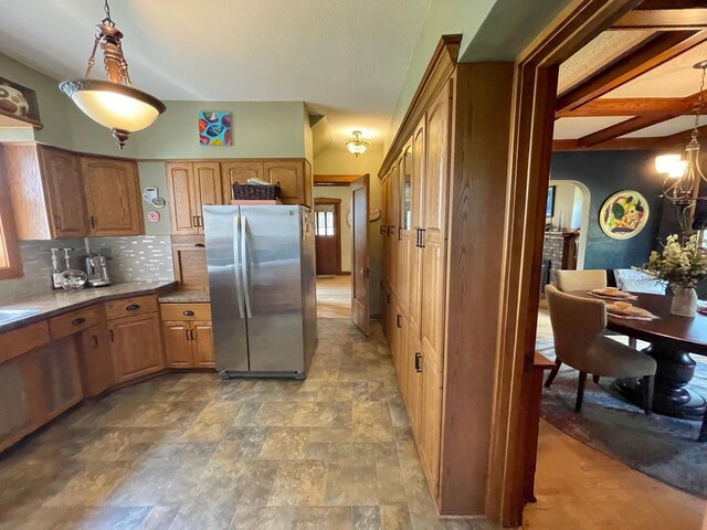 38364 200th St, Springfield, MN 56087 - kitchen with freestanding refrigerator, pendant lighting, a brick fireplace, stone finish floor, and tasteful backsplash