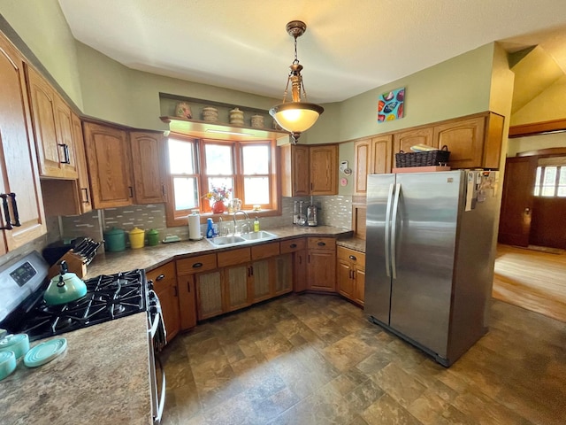 38364 200th St, Springfield, MN 56087 - kitchen featuring brown cabinetry, backsplash, a sink, light countertops, and stainless steel appliances