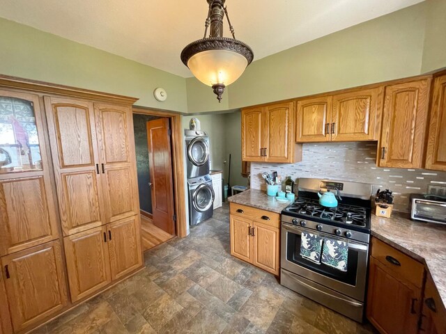 38364 200th St, Springfield, MN 56087 - kitchen featuring stainless steel gas range, hanging light fixtures, stone finish floor, decorative backsplash, and stacked washer and clothes dryer