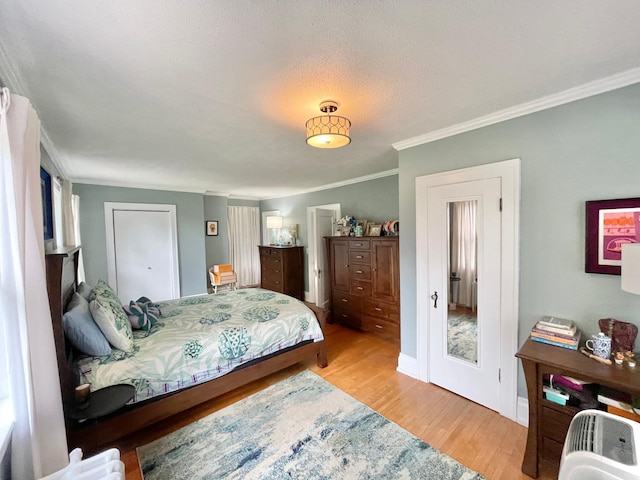 bedroom featuring light hardwood / wood-style flooring, a textured ceiling, and ornamental molding