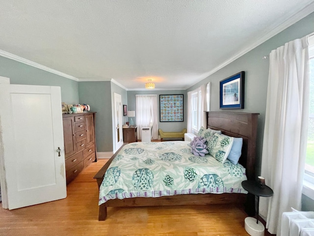 bedroom featuring multiple windows, crown molding, a textured ceiling, and light wood-type flooring