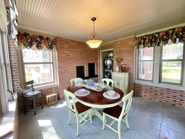 dining space with wood ceiling and brick wall