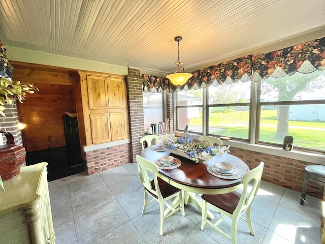 dining area with brick wall and wood ceiling