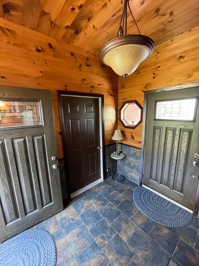 foyer with wood ceiling and wooden walls