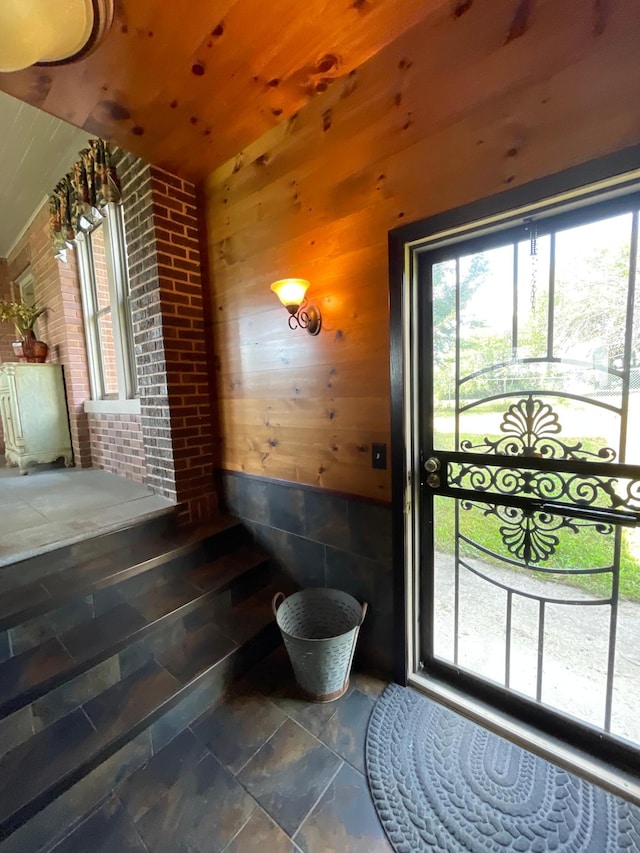 entryway with wood walls