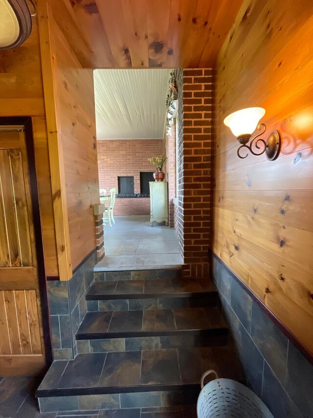 38364 200th St, Springfield, MN 56087 - stairs with stone tile flooring, wood walls, wood ceiling, and a brick fireplace