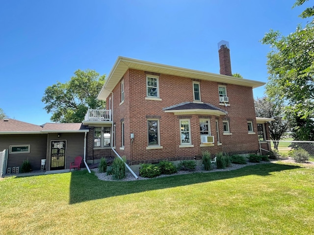 back of property featuring a lawn, cooling unit, and a balcony