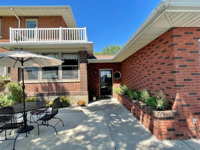 38364 200th St, Springfield, MN 56087 - entrance to property featuring a patio, outdoor dining area, brick siding, and a balcony