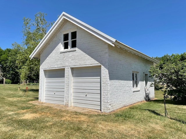 38364 200th St, Springfield, MN 56087 - view of side of property featuring an outdoor structure, a yard, brick siding, and a detached garage