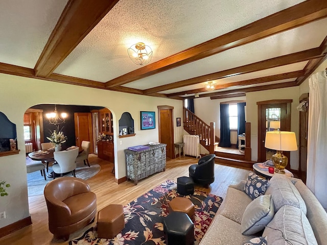 living room featuring a textured ceiling, wood-type flooring, beam ceiling, radiator, and a notable chandelier