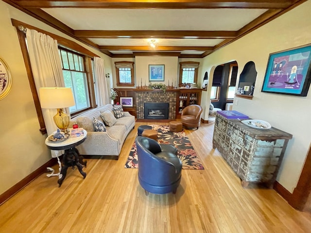 living room with a fireplace, beam ceiling, and light hardwood / wood-style flooring