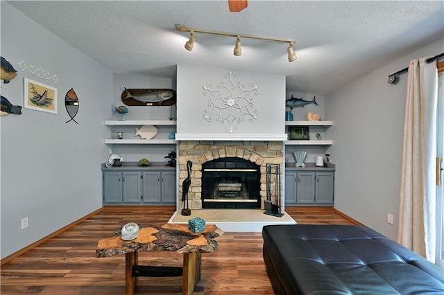 living room featuring a textured ceiling, a fireplace, and dark wood-type flooring