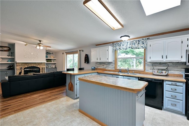 kitchen featuring a kitchen island, white cabinetry, dishwasher, and ceiling fan