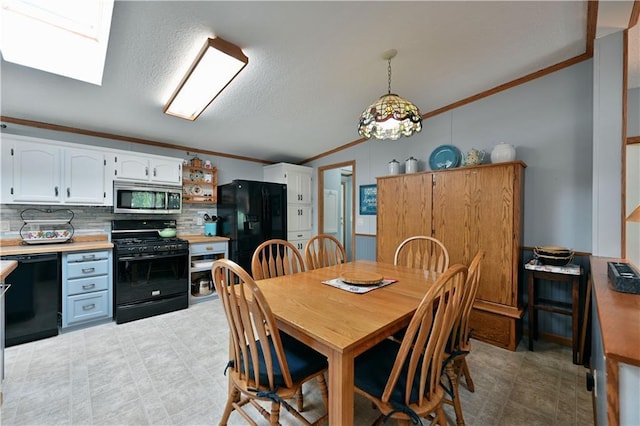 dining room with a skylight and crown molding