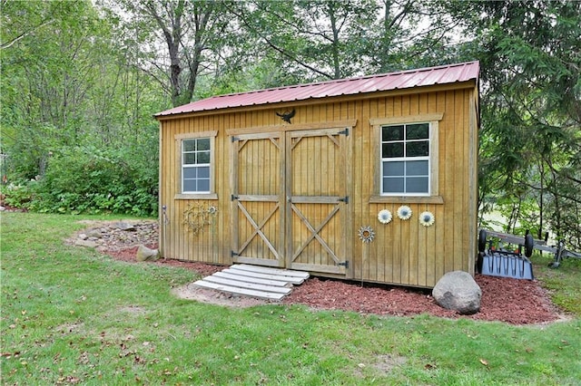 view of outbuilding featuring a lawn