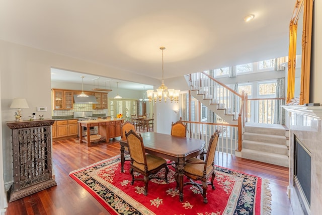 dining room featuring a chandelier, stairway, and wood finished floors