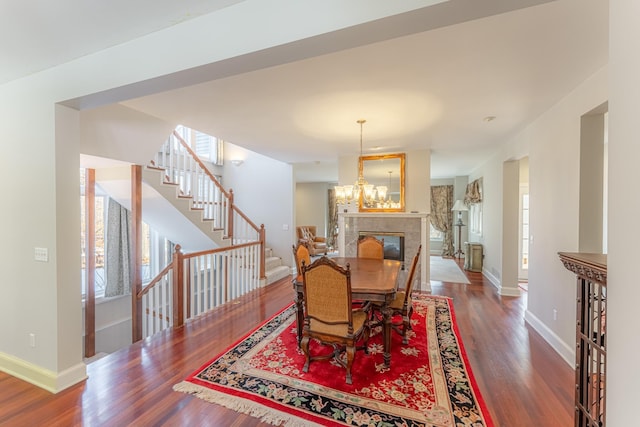 dining room featuring baseboards, wood finished floors, and stairs