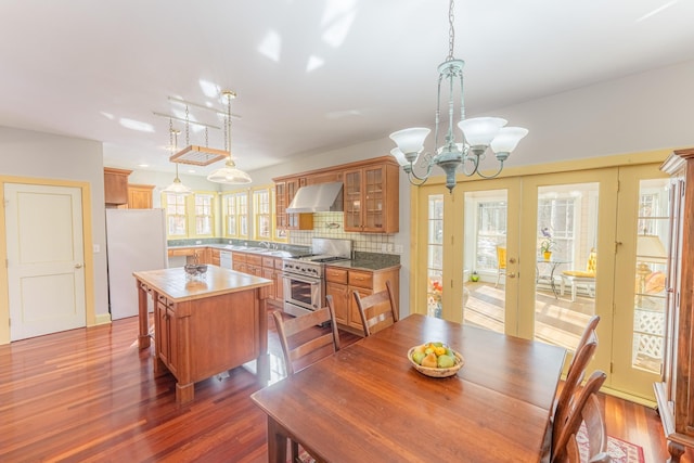 dining space with an inviting chandelier, dark wood-type flooring, and french doors