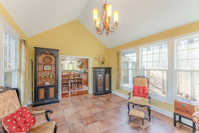 sitting room featuring a wealth of natural light, baseboards, a notable chandelier, and vaulted ceiling