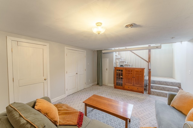 living area with baseboards, stairway, light carpet, and visible vents