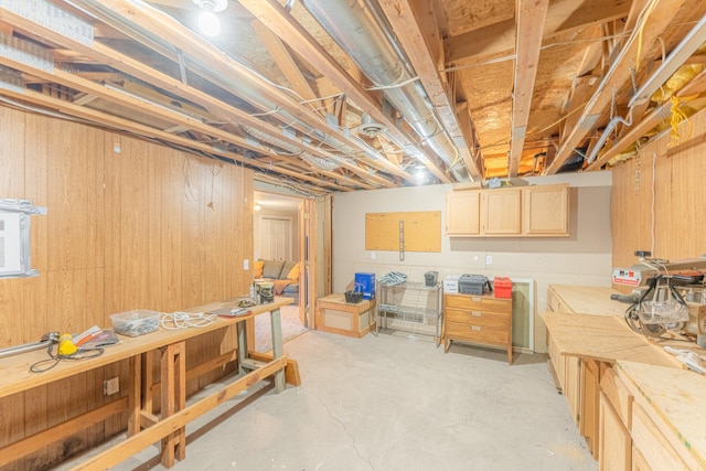 unfinished basement with a workshop area and wood walls