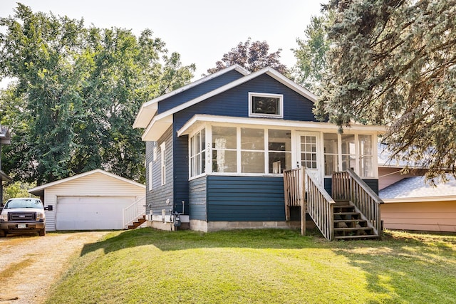 bungalow with a sunroom, an outdoor structure, a front yard, and a garage