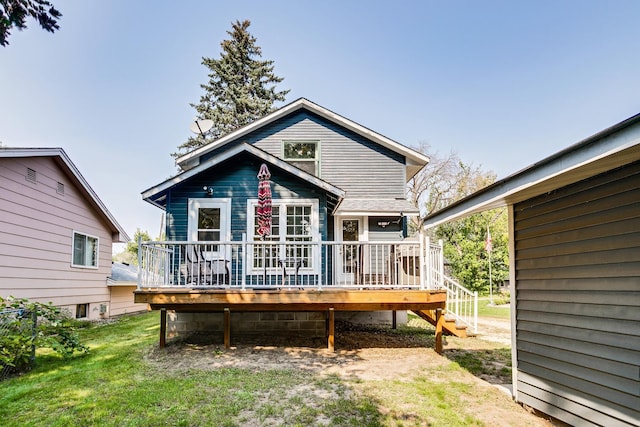 back of house with a lawn and a deck