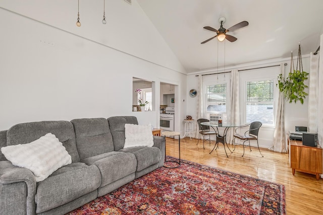 living room with high vaulted ceiling, ceiling fan, and hardwood / wood-style flooring